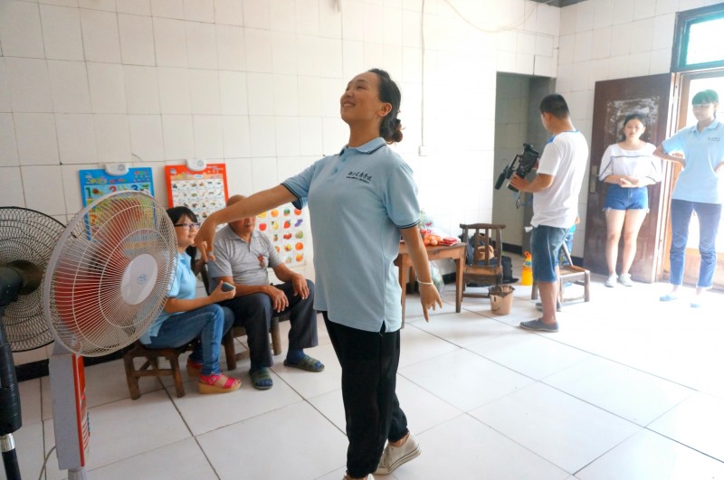 图三：队员杜娟为孙明文老人跳起了优美的军旅舞  摄影：吴敏