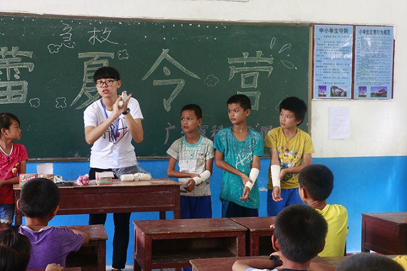 教员叶诗敏正在向孩子们演示正确的包扎方法。(魏与 摄)