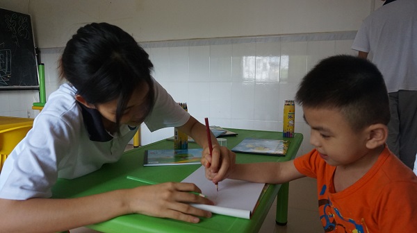 配图2：队员教孩子写字。 通讯员叶子莹 拍摄