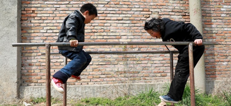        3月26日，邵存宇和邵婉玉在校园内的简易双杠前锻炼玩耍。