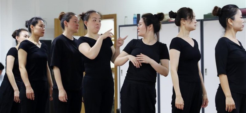 5月26日，两名舞蹈队员在聊天。 在上海闵行区古美路街道，有一个由听力障碍者组成的舞蹈团队——古美彩韵聋人舞蹈艺术队。舞蹈队现有20名队员，年龄从20岁到40岁，由上海戏剧学院舞蹈学院的老师每周一次为队员们提供训练指导。对舞蹈艺术的热爱，让这些听力障碍者走到了一起，在无声世界里舞出精彩人生。