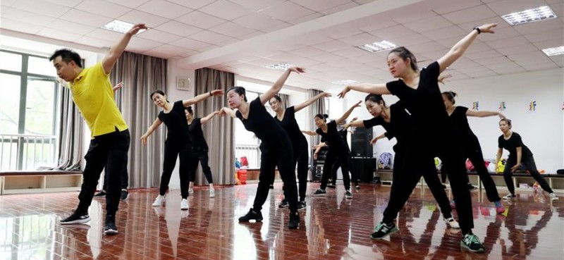 5月26日，上海戏剧学院舞蹈学院刘建强老师（左）带领队员们排练舞蹈。 在上海闵行区古美路街道，有一个由听力障碍者组成的舞蹈团队——古美彩韵聋人舞蹈艺术队。舞蹈队现有20名队员，年龄从20岁到40岁，由上海戏剧学院舞蹈学院的老师每周一次为队员们提供训练指导。对舞蹈艺术的热爱，让这些听力障碍者走到了一起，在无声世界里舞出精彩人生。