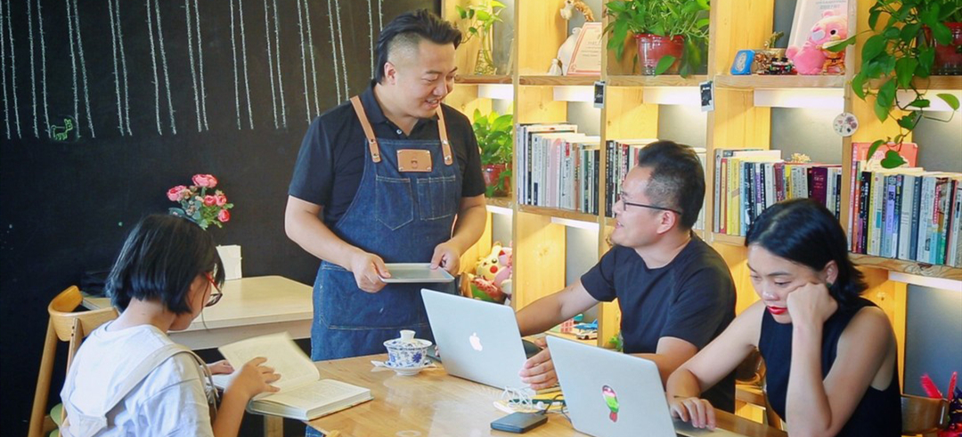 八月的午后还有些炎热，创业青年坚春天穿着工作服，忙碌的身影穿梭在屋前屋后。这个“深居”在大华·1935园区内的咖啡店便是他的梦想承载地。图为坚春天在咖啡馆内忙碌招待顾客。来源：新华网