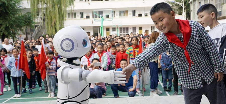 9月2日，在城口县蓼子乡第一中心小学开学典礼上，机器人老师在和孩子进行互动交流。