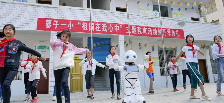 9月2日，在城口县蓼子乡第一中心小学开学典礼上，机器人老师和孩子们一起跳舞。