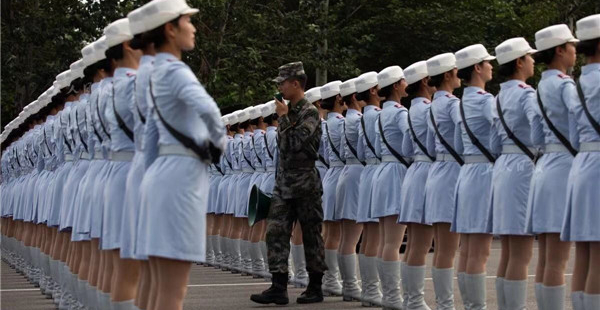 民兵方队的女兵正在接受训练。训练场地空旷，为了保护教官的嗓子，每人都配备了扩音器。