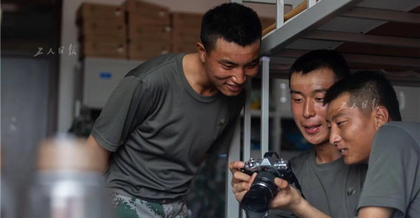 回到宿舍后，一名喜爱摄影的战士正在给战友们分享自己拍摄的照片。