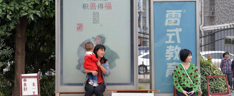 10月9日，在南昌市青山湖区顺外路口的公交车站，市民坐在爱心椅上候车。