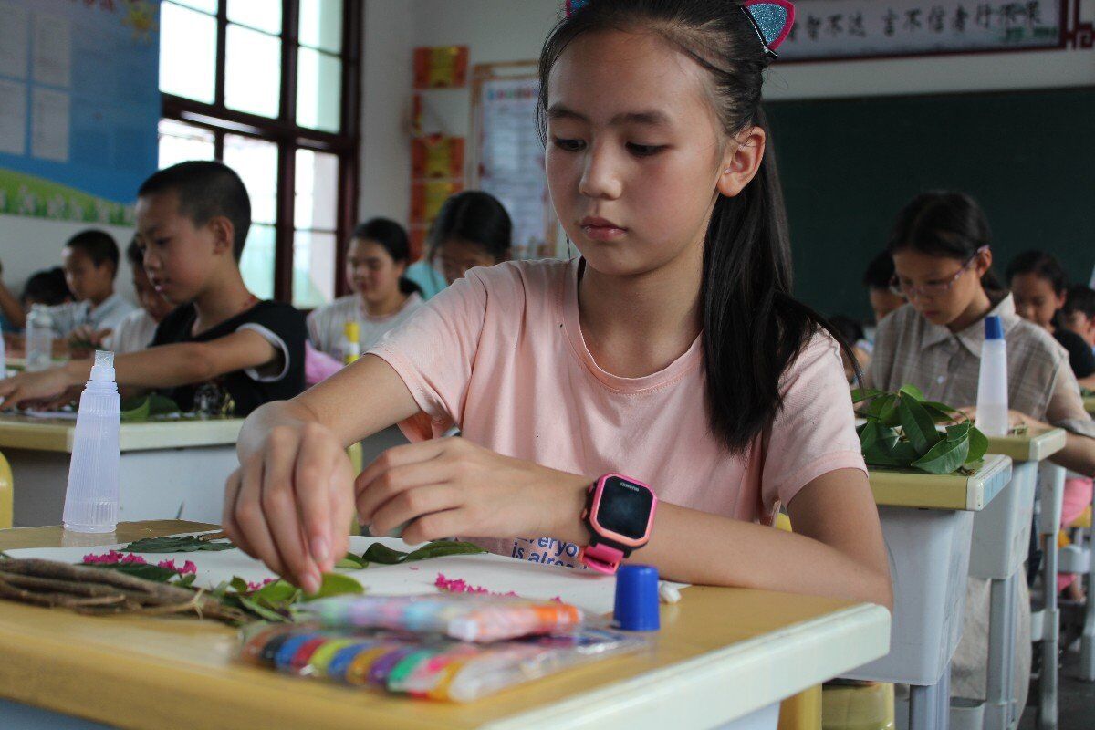 陇城镇中心小学学生正在进行树叶拼贴画的创作