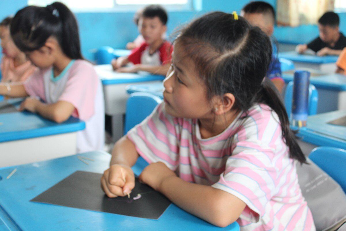 陇城镇中心小学的学生在实践队队员的带领下进行绘画