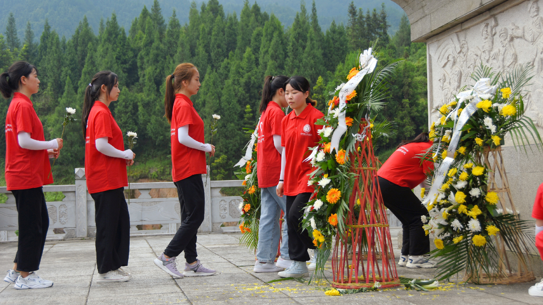 图为实践团成员排队到纪念碑前献花