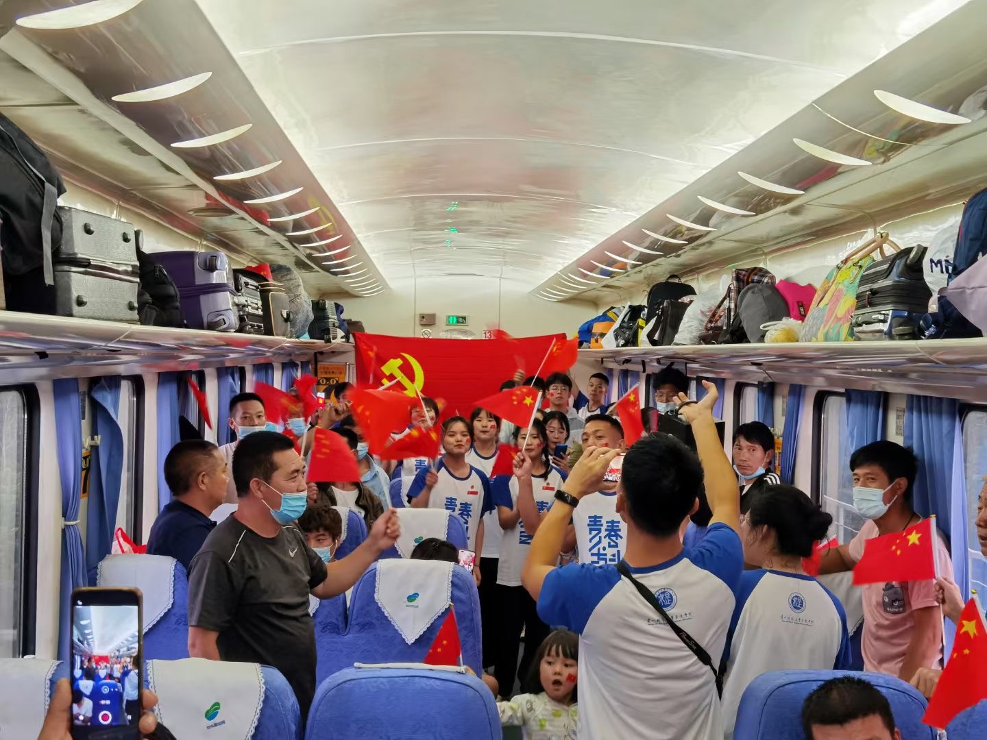队员和乘客列车上互动，共唱红歌。（田嘉伟摄）