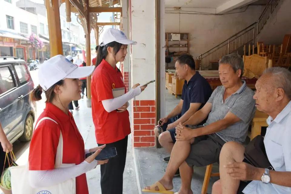 图为实践团队员在甘溪乡集市进行随机调研(1)