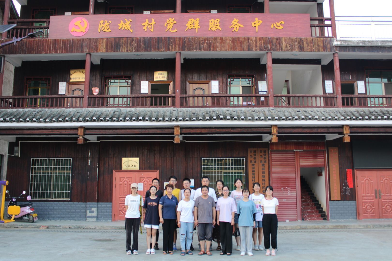 图为村干部与赤行队队员在陇城村党群服务中心门口合影留恋