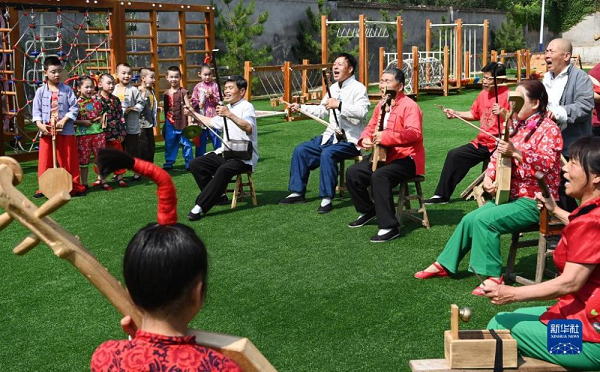 　　5月26日，黄河老腔艺术团的老艺人在幼儿园为孩子们传授老腔艺术技巧。新华社记者 陶明 摄